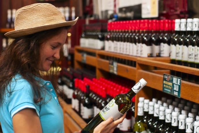 shopping-a-girl-in-a-wine-shop-holding-a-bottle-of-wine_t20_AlREGV